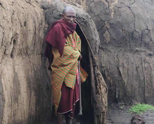 Tijdens uw 7 Dagen Safari Tanzania krijgt u de kans om de lokale bevolking en cultuur te leren kennen, zoals deze oudere Maasai voor een traditionele Boma van leem.