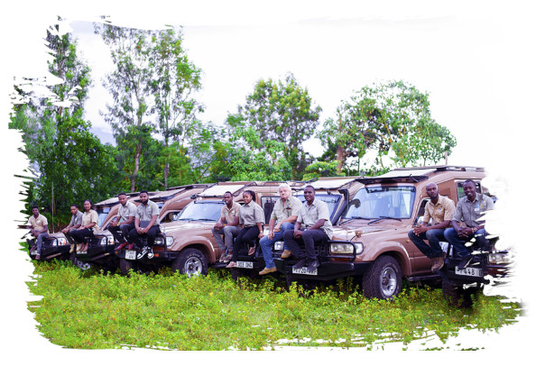 Onze safarigidsen en ander personeel zittend op de motorkap van verschillende Shemeji Safari Trucks
